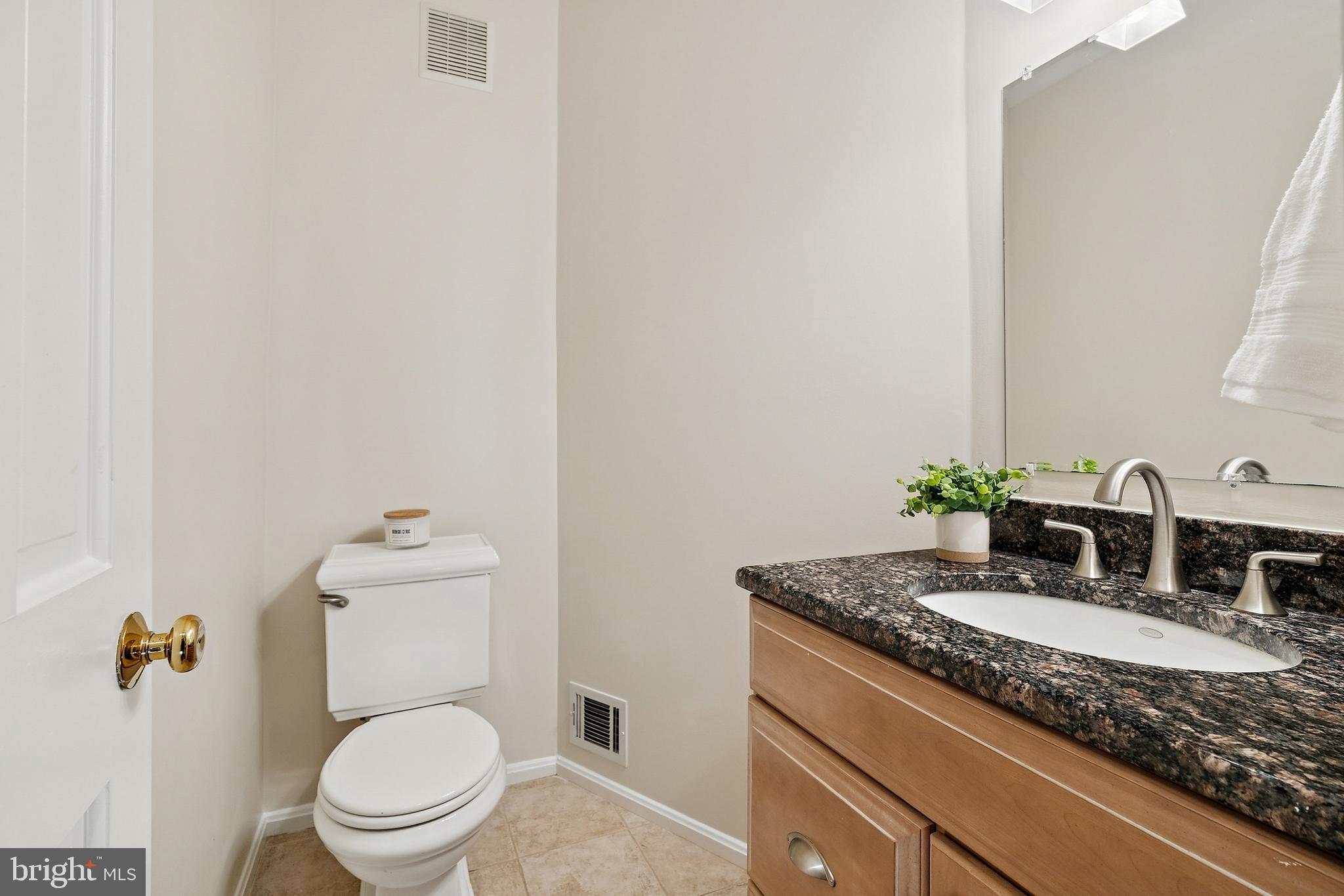 7810 Ashley Glen Road Annandale, VA 22003 - Photo 11 of 33 a bathroom with a granite countertop sink a toilet and mirror