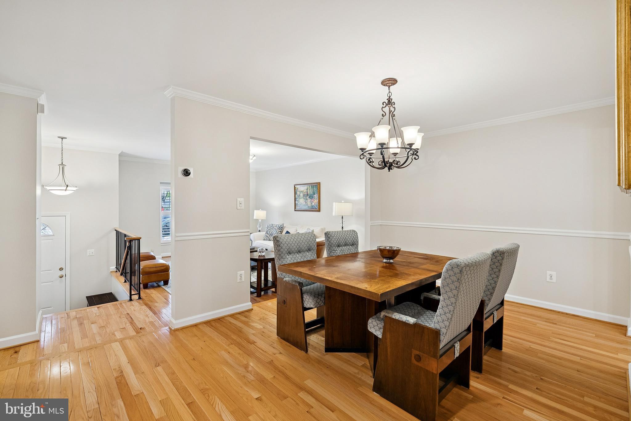 7810 Ashley Glen Road Annandale, VA 22003 - Photo 4 of 33 a dining room with wooden floor a chandelier a wooden table and chairs