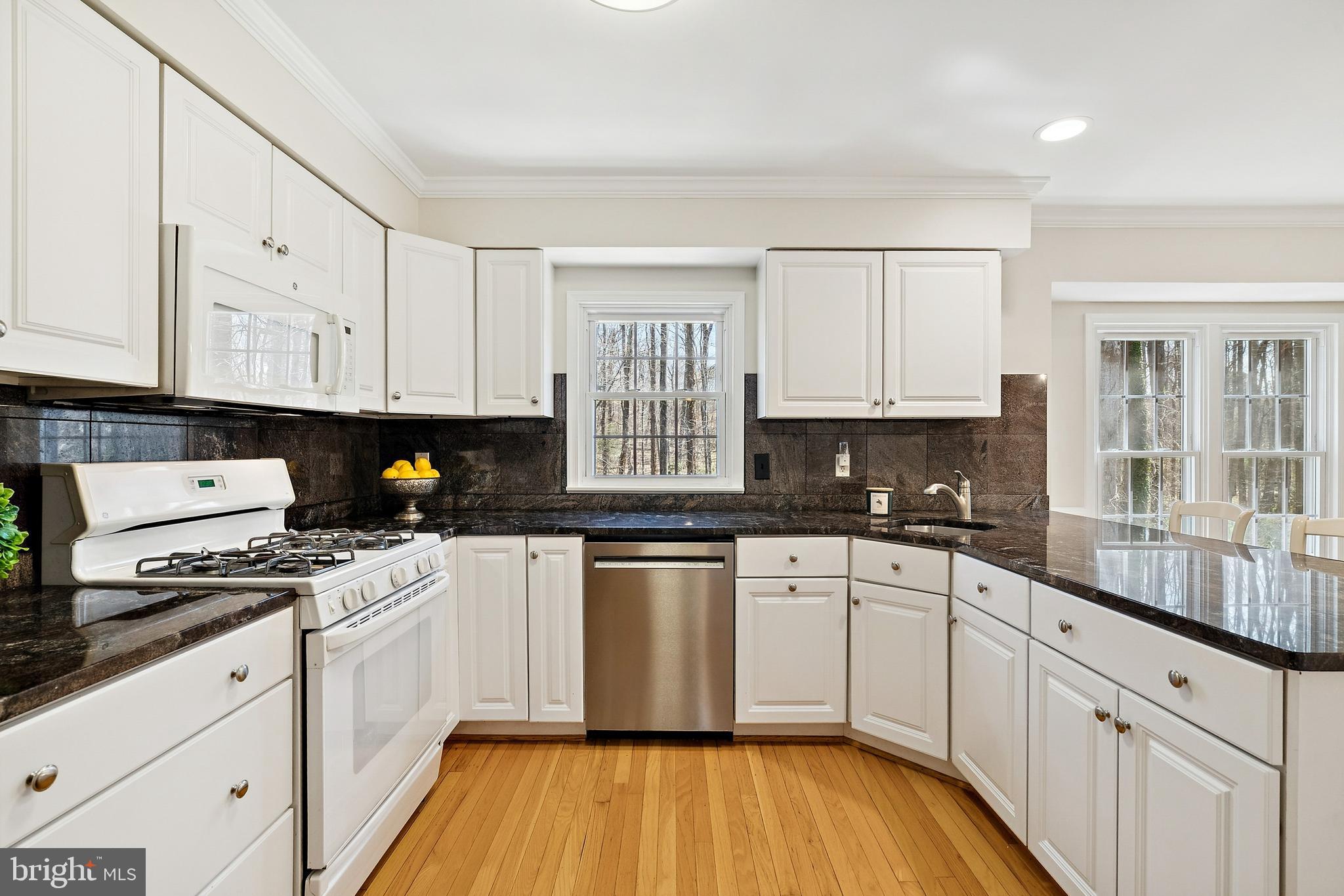 7810 Ashley Glen Road Annandale, VA 22003 - Photo 8 of 33 a kitchen with granite countertop a stove sink and cabinets