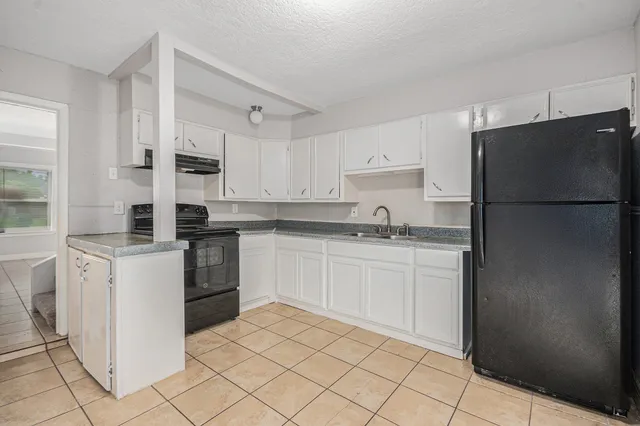 a kitchen with white cabinets and white appliances