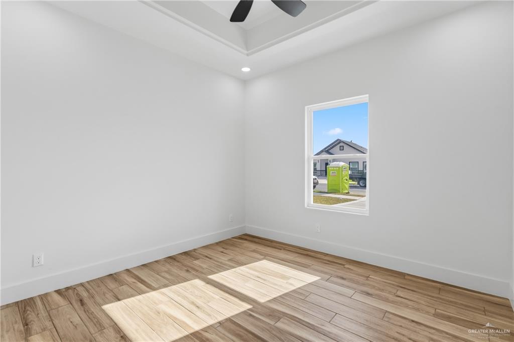 1921 Trinity Street Donna, TX 78537 - Photo 11 of 18 an empty room with wooden floor and windows