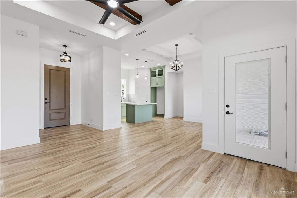 1921 Trinity Street Donna, TX 78537 - Photo 4 of 18 a view of an empty room with wooden floor and a kitchen