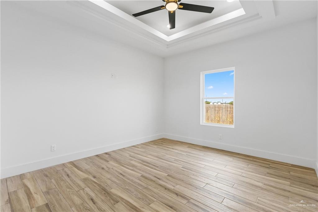 1921 Trinity Street Donna, TX 78537 - Photo 8 of 18 an empty room with a window and a ceiling fan