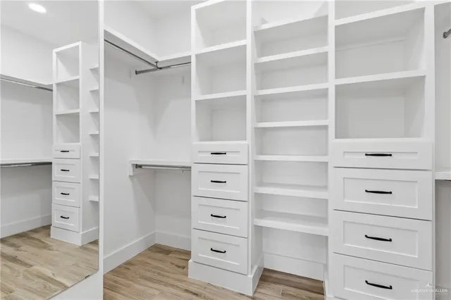 a view of walk in closet with clothes