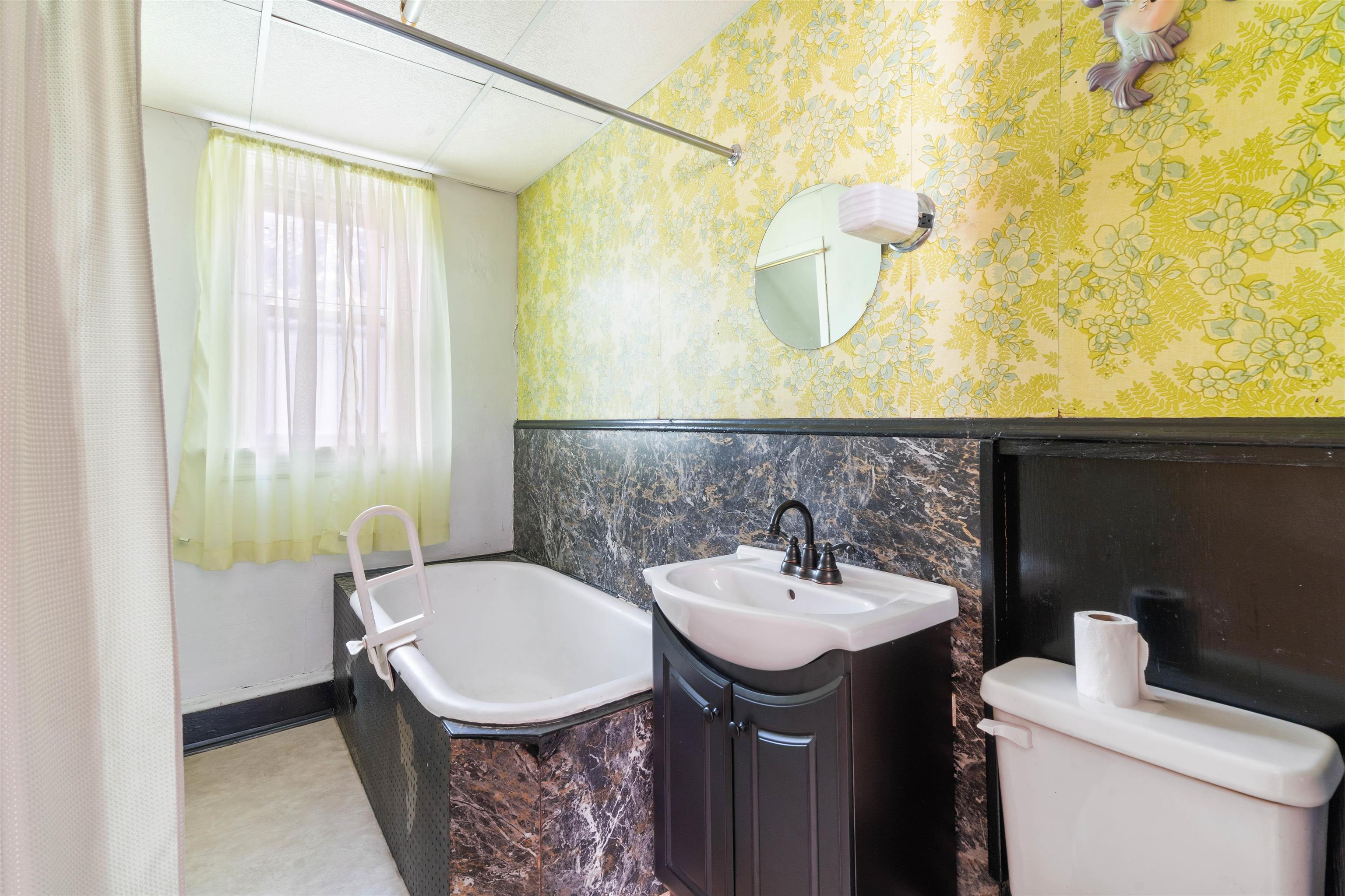 1301 North 11th Street Superior, WI 54880 - Photo 13 of 21 Bathroom featuring vanity, a garden tub, a wainscoted wall, wallpapered walls, and tile walls