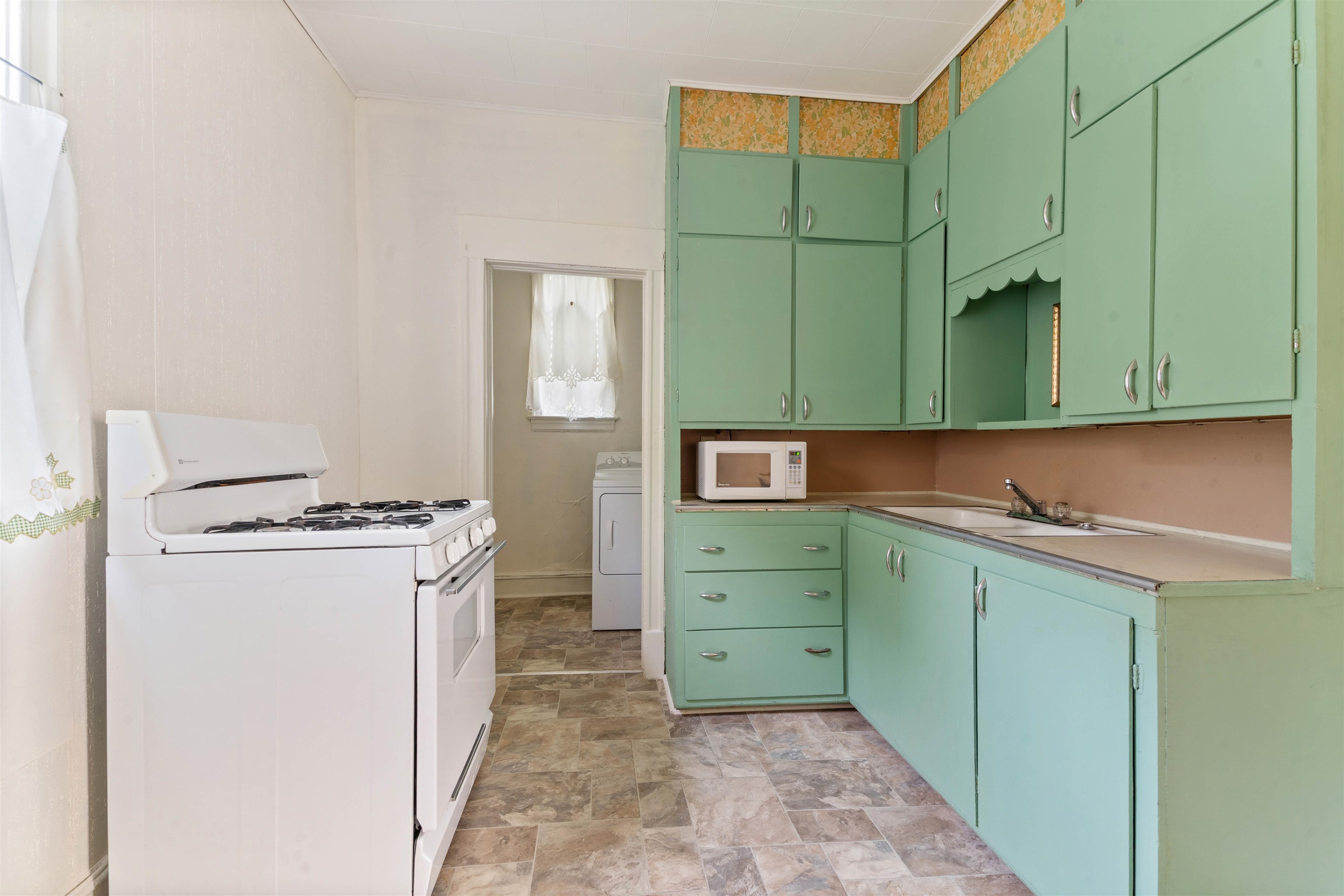 1301 North 11th Street Superior, WI 54880 - Photo 6 of 21 Kitchen with white appliances, stone finish floors, washer / clothes dryer, light countertops, and green cabinetry