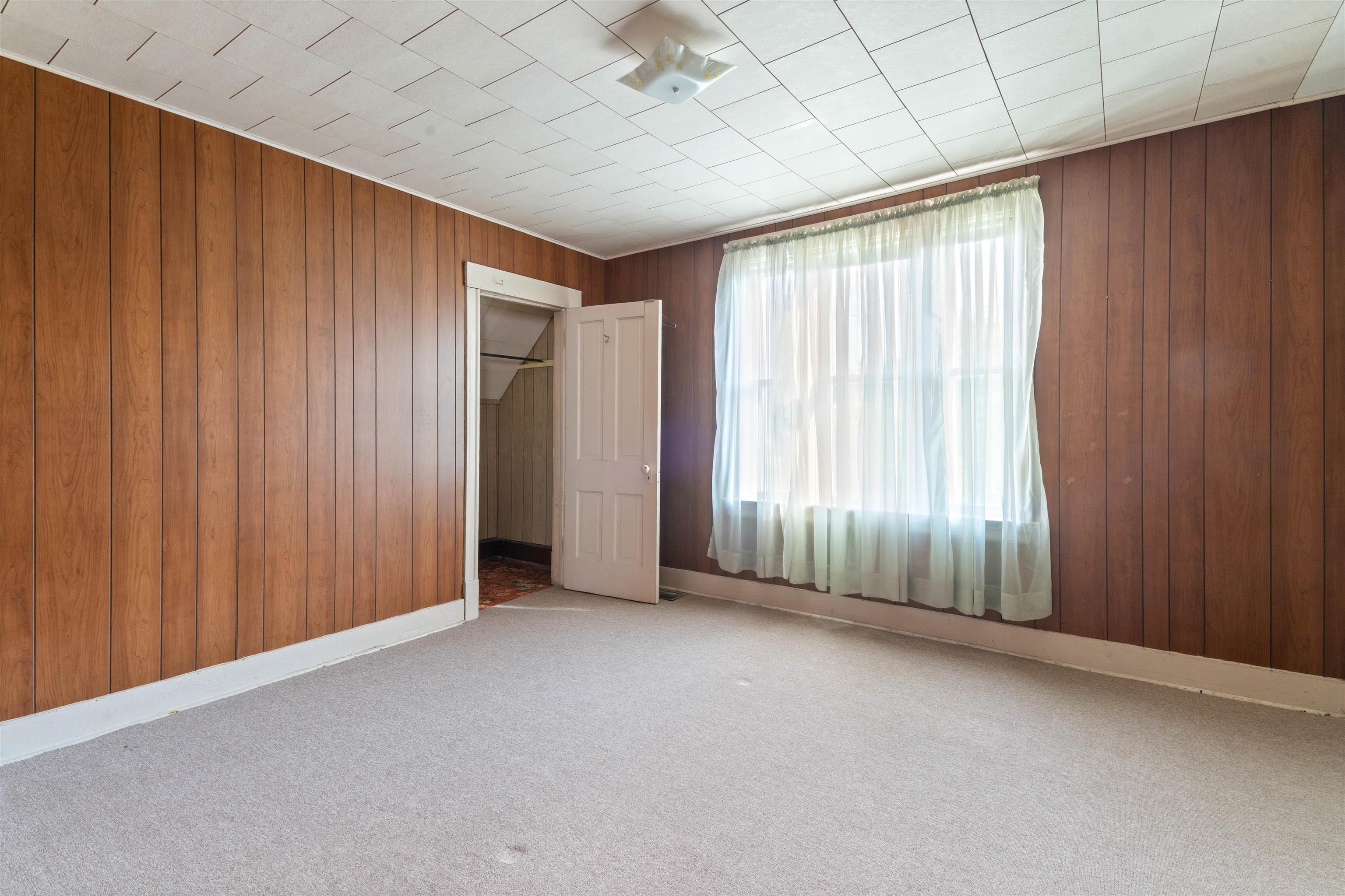 1301 North 11th Street Superior, WI 54880 - Photo 10 of 21 Unfurnished bedroom with wood walls, carpet flooring, and a walk in closet