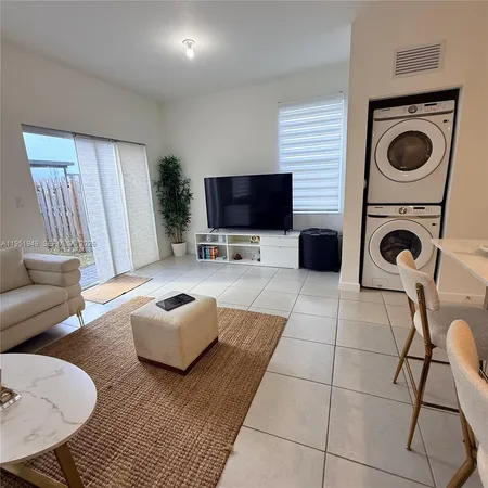 a kitchen with stainless steel appliances kitchen island granite countertop a table chairs and a refrigerator