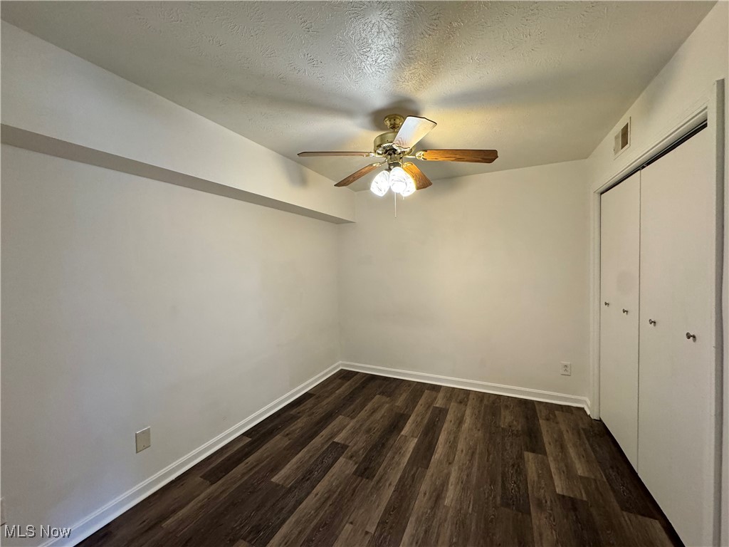 8961 Herbert Road Canfield, OH 44406 - Photo 20 of 26 Unfurnished bedroom featuring a closet, ceiling fan, visible vents, baseboards, and dark wood-style floors