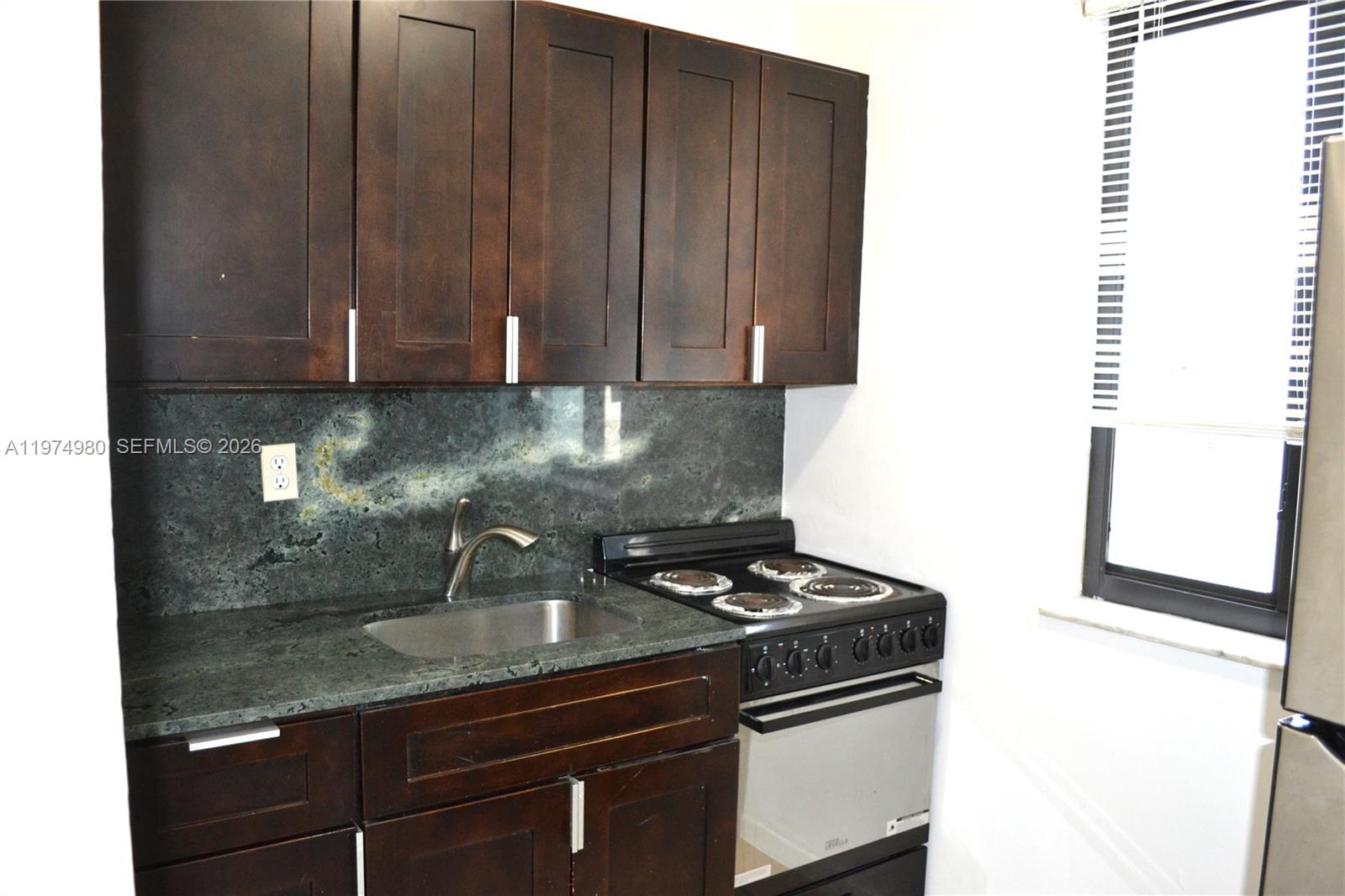 1035 Southwest 4th Street, Unit 2 Miami, FL 33130 - Photo 6 of 11 a kitchen with granite countertop a sink and a stove