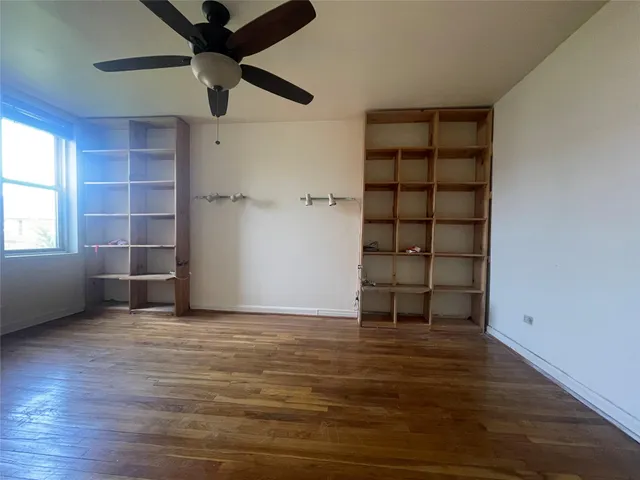 an empty room with cabinet and windows