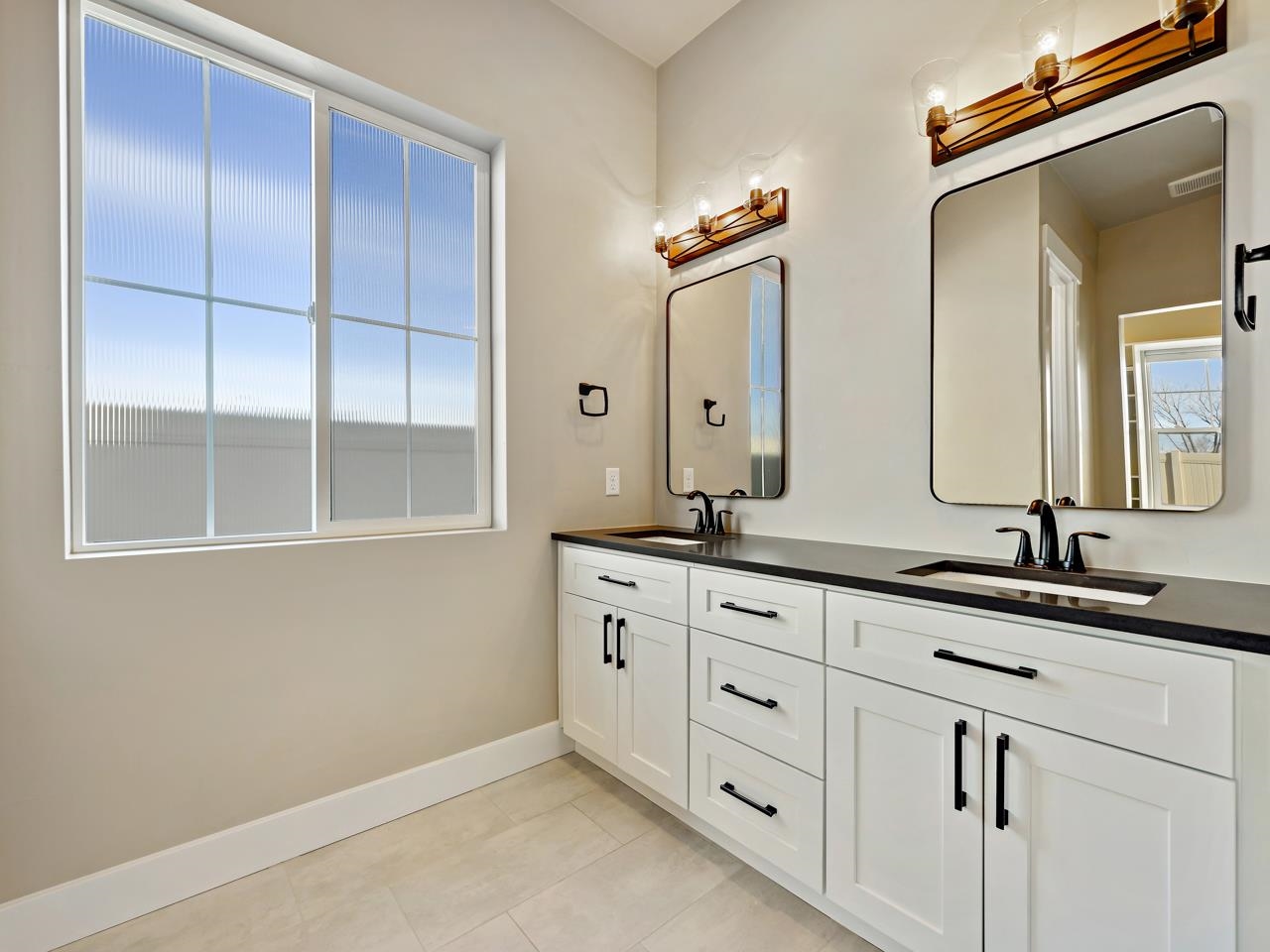 823 Red Apple Road Grand Junction, CO 81505 - Photo 15 of 38 a bathroom with a double vanity sink and a mirror