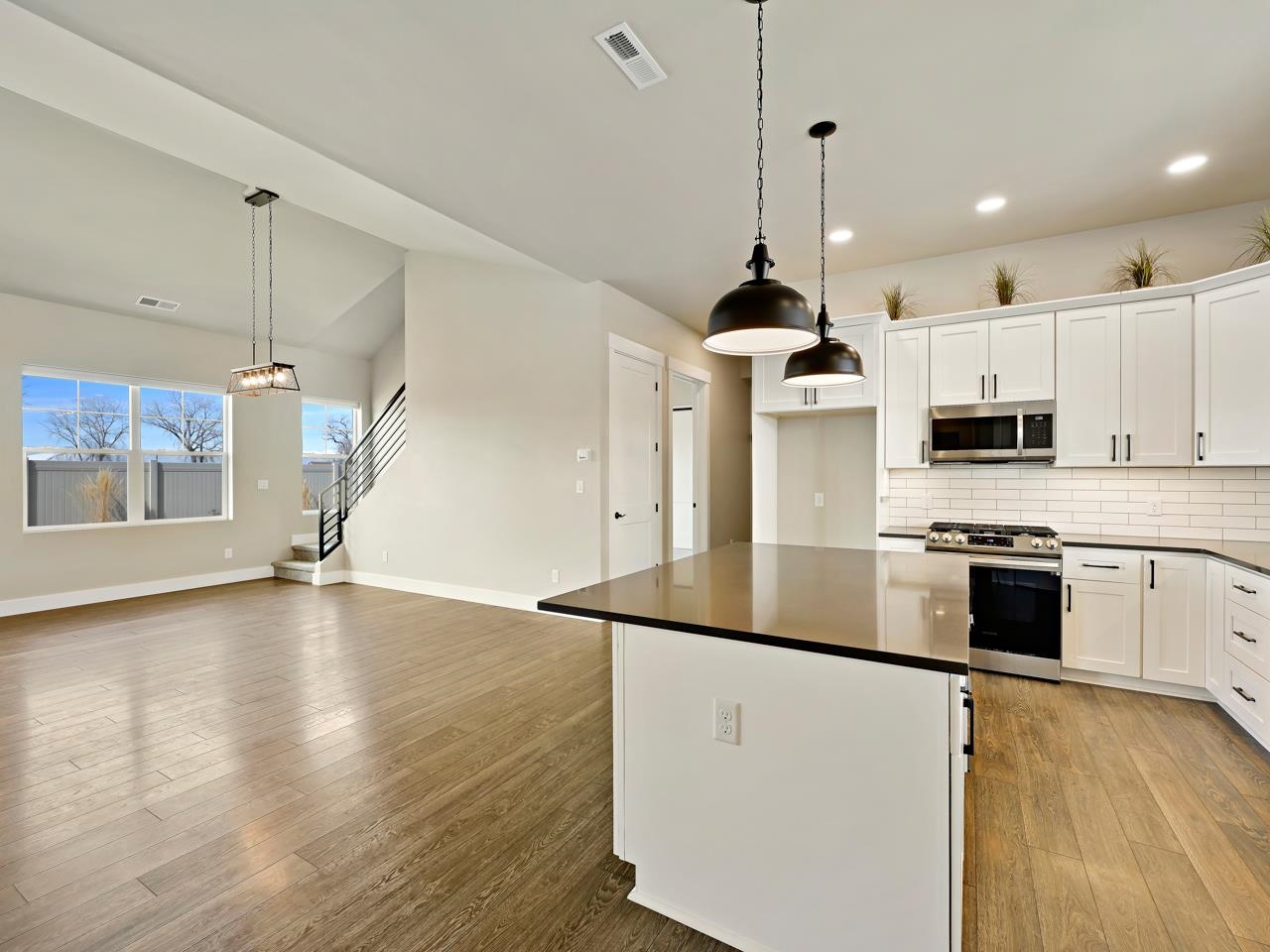 823 Red Apple Road Grand Junction, CO 81505 - Photo 5 of 38 a kitchen with stainless steel appliances granite countertop a sink a stove a refrigerator and white cabinets with wooden floor