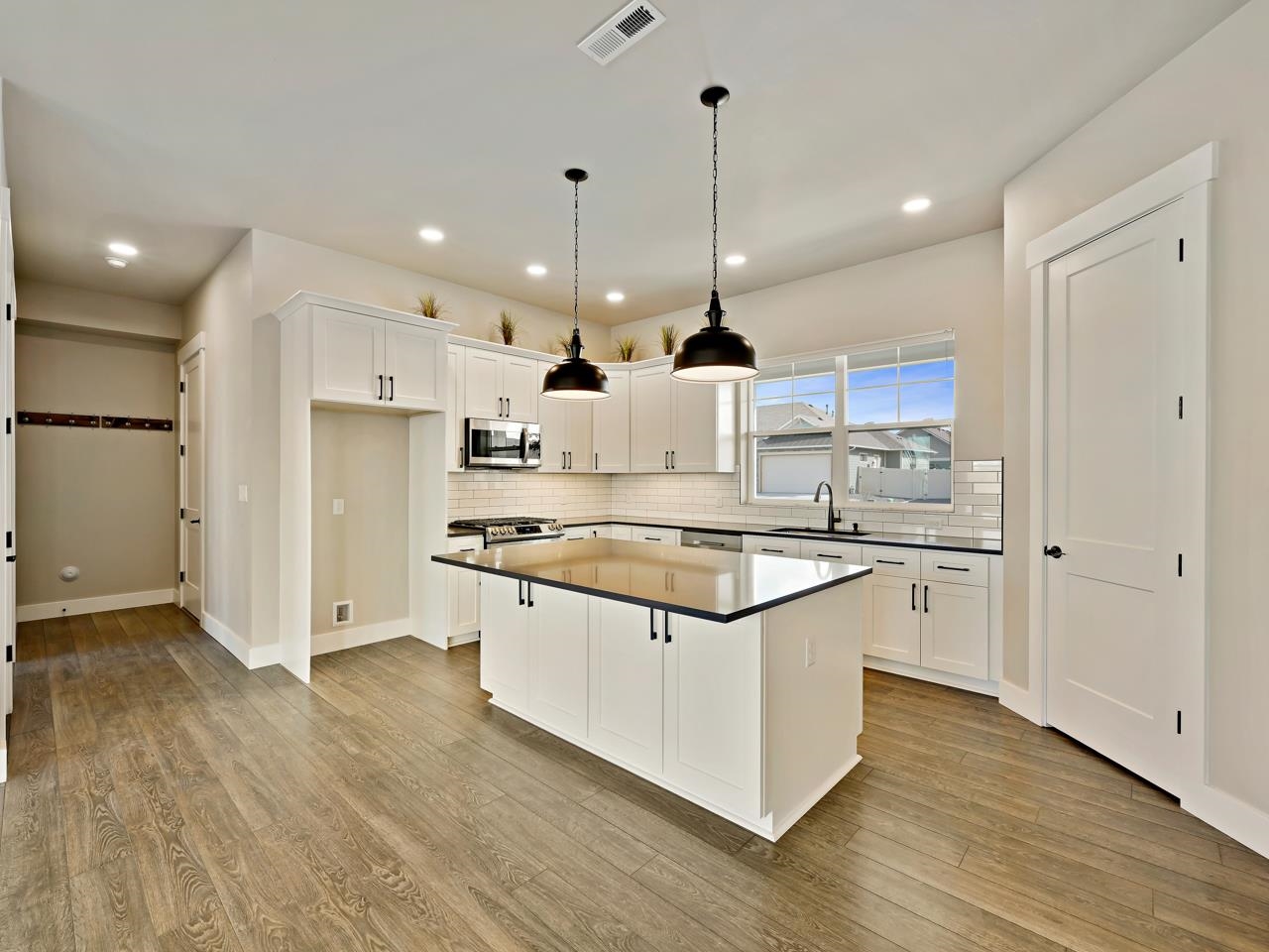823 Red Apple Road Grand Junction, CO 81505 - Photo 6 of 38 a kitchen with stainless steel appliances granite countertop a sink a stove a refrigerator and a wooden floor