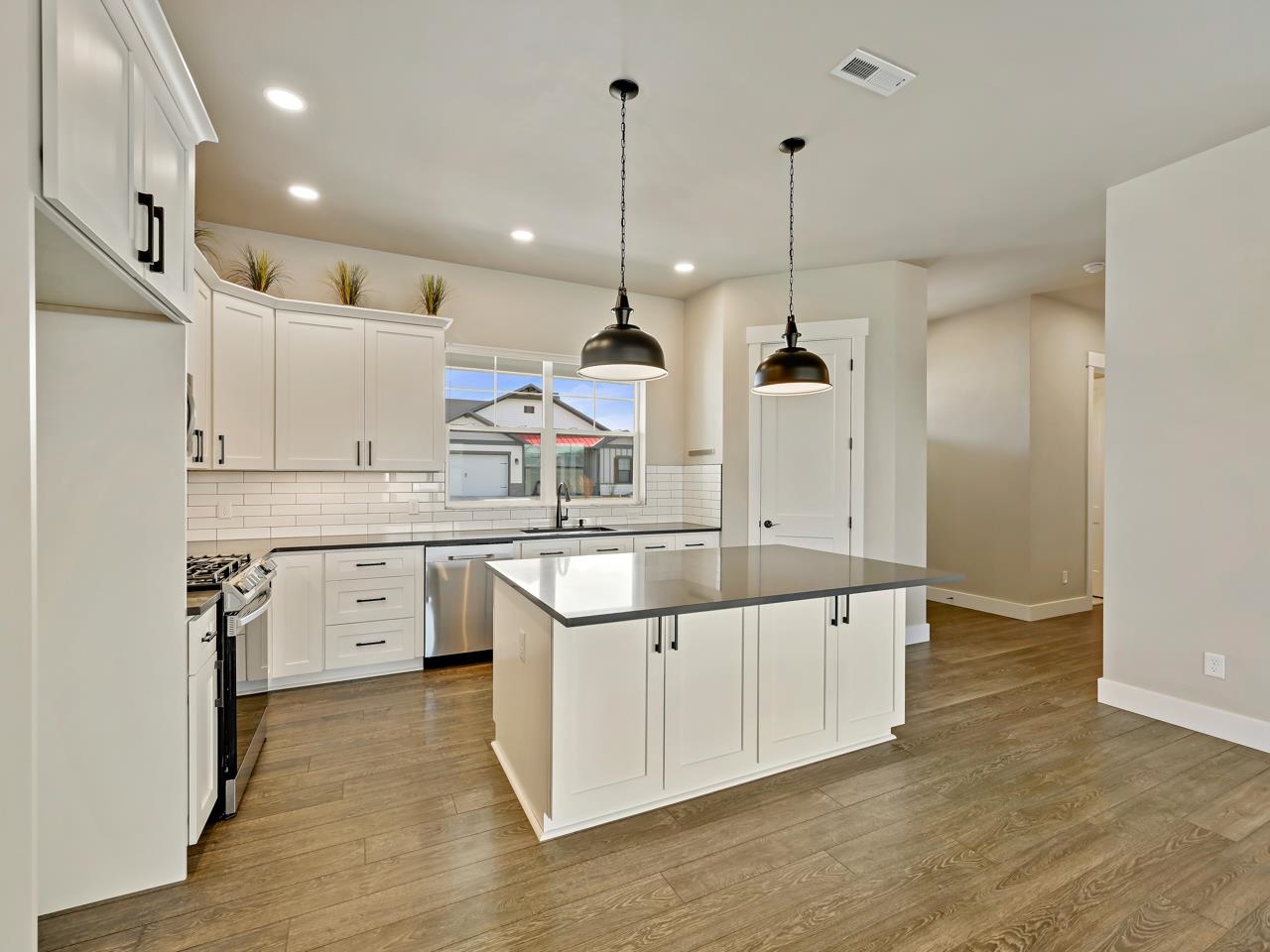 823 Red Apple Road Grand Junction, CO 81505 - Photo 7 of 38 a kitchen with white cabinets appliances and wooden floor