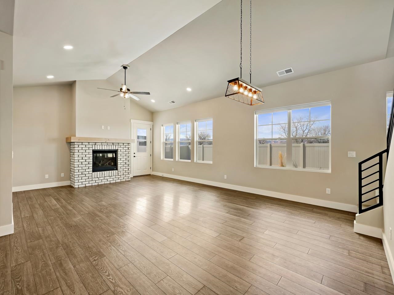 823 Red Apple Road Grand Junction, CO 81505 - Photo 10 of 38 an empty room with wooden floor fireplace and windows