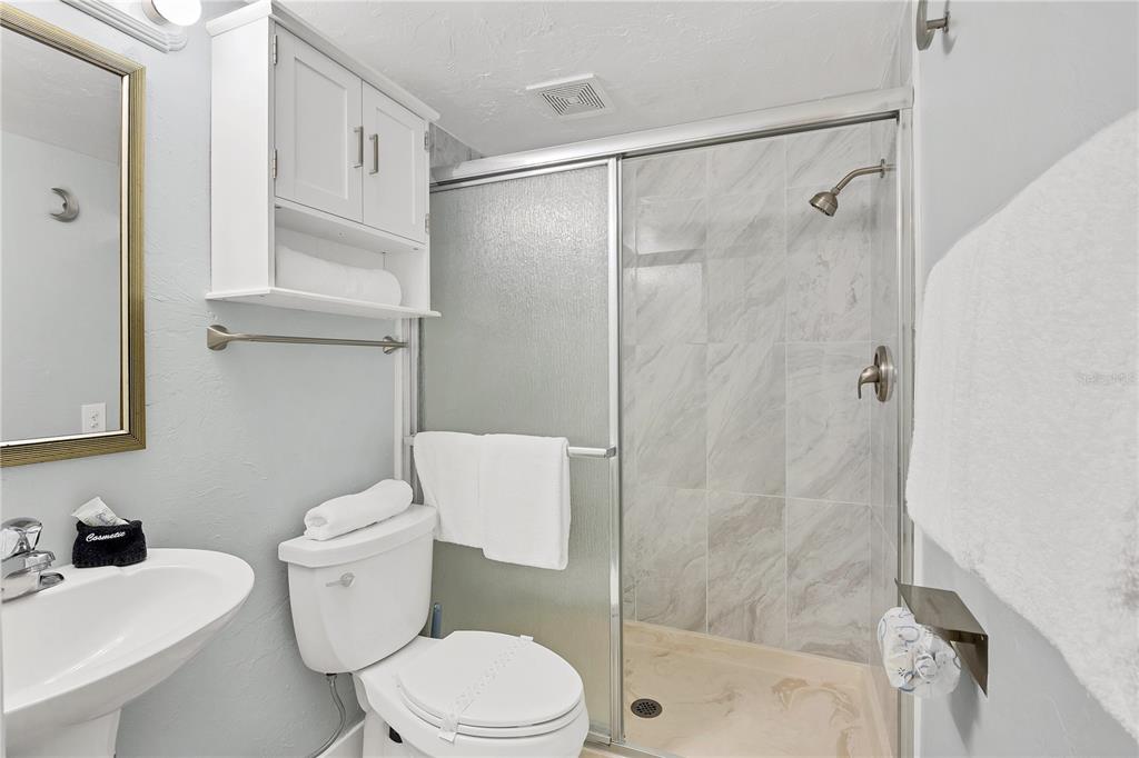6006 Midnight Pass Road, Unit 21 Sarasota, FL 34242 - Photo 15 of 24 a white toilet sitting next to a bathroom sink
