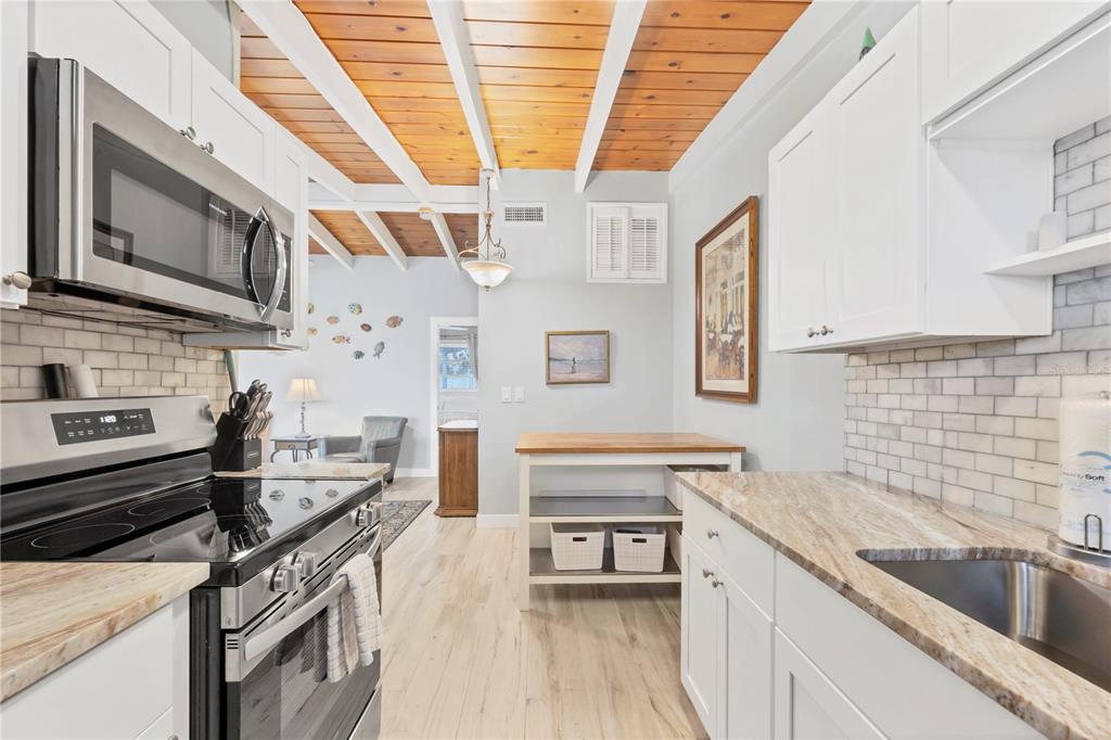 6006 Midnight Pass Road, Unit 21 Sarasota, FL 34242 - Photo 9 of 24 a kitchen with stainless steel appliances granite countertop a sink and a stove