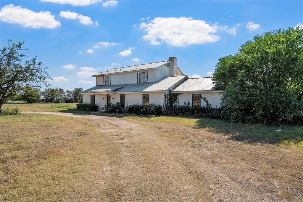 a front view of a house with a yard and a fountain