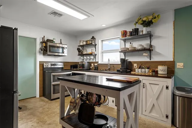 a kitchen with stainless steel appliances granite countertop a sink and cabinets