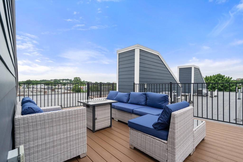32 Pearl Street, Unit 4 Boston, MA 02125 - Photo 29 of 35 a roof deck with couches and wooden floor