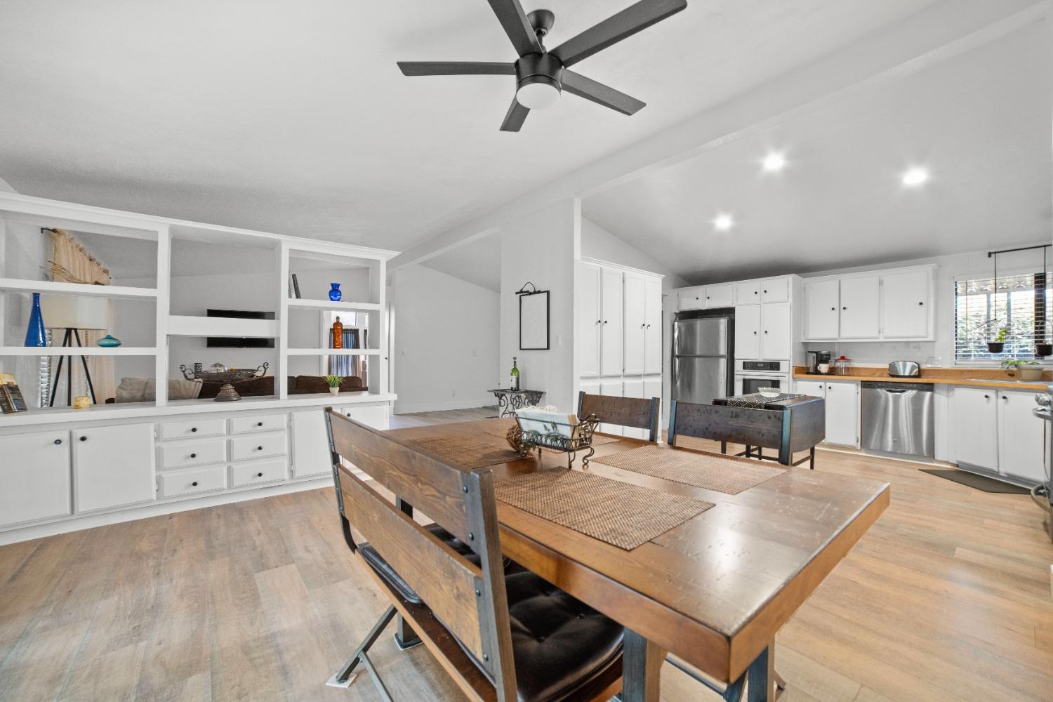 a kitchen with stainless steel appliances cabinets dining table and chairs