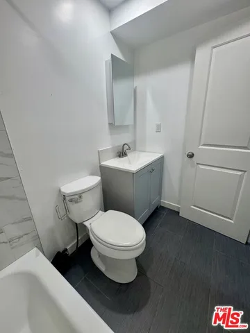 a white toilet sitting next to a bathroom sink