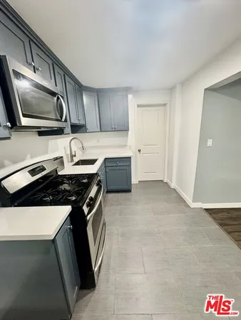 a kitchen with granite countertop a sink and a stove top oven