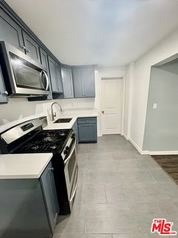 a kitchen with granite countertop a sink and a stove top oven