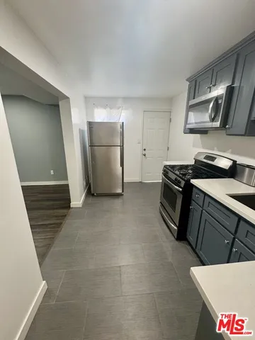 a kitchen with stainless steel appliances a stove a refrigerator and cabinets