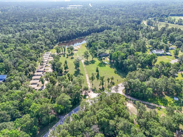 an aerial view of residential house with outdoor space and trees all around
