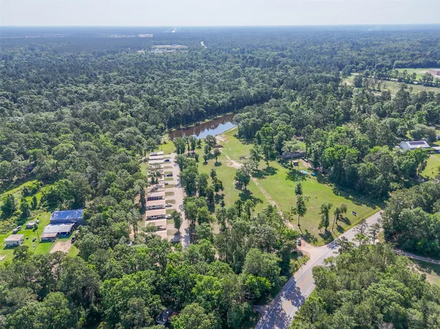 an aerial view of a house with a yard and lake view
