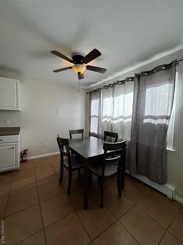 a kitchen with stainless steel appliances a table chairs and a refrigerator