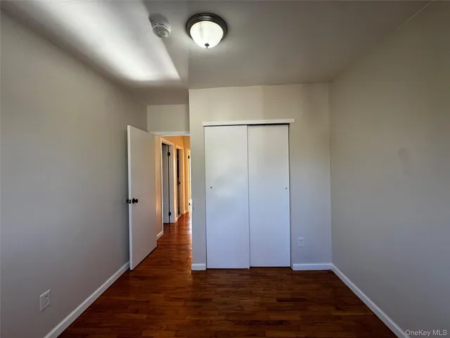 an empty room with wooden floor and closet