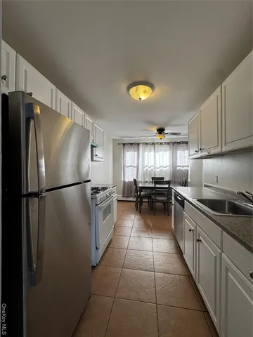 a kitchen with a refrigerator a sink and a stove top oven
