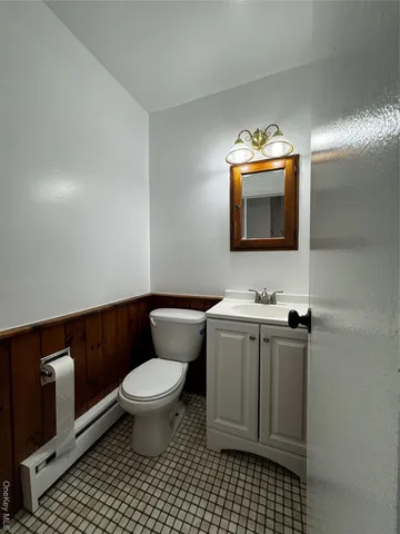 a bathroom with a toilet a sink and mirror