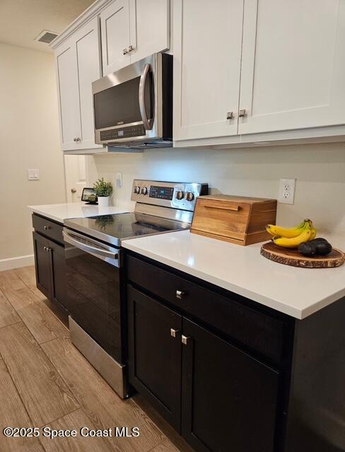 1807 Elkins Point Melbourne, FL 32935 - Photo 10 of 13 a kitchen with stainless steel appliances a sink dishwasher stove and microwave with wooden cabinets