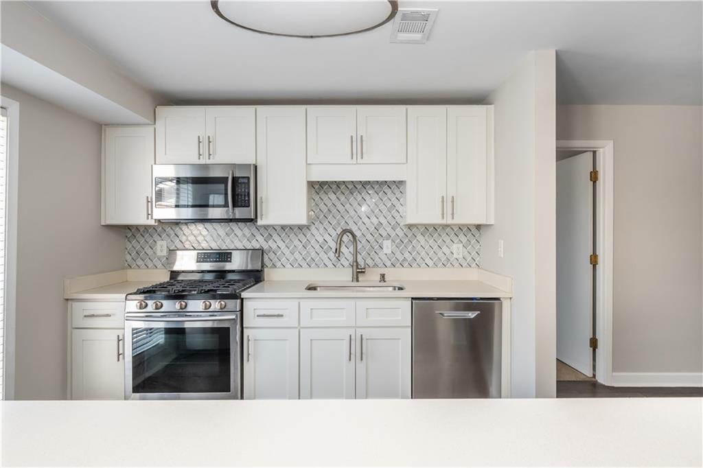 1211 Wynnes Ridge Circle Marietta, GA 30067 - Photo 14 of 35 a kitchen with stainless steel appliances a sink stove and cabinets