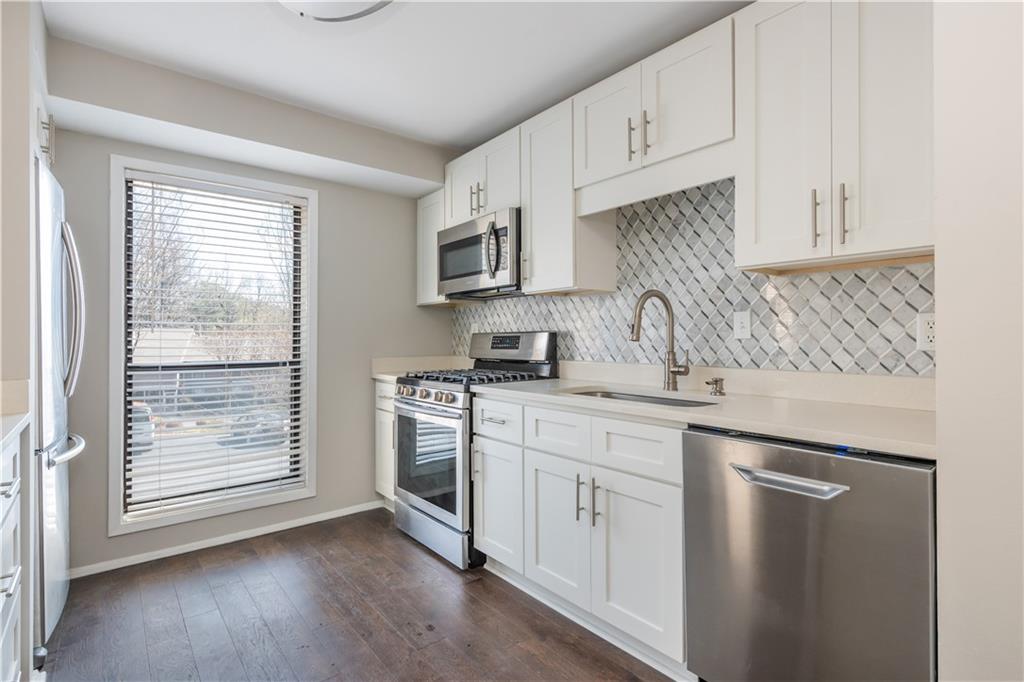 1211 Wynnes Ridge Circle Marietta, GA 30067 - Photo 6 of 35 a kitchen with stainless steel appliances granite countertop a sink a stove and a refrigerator