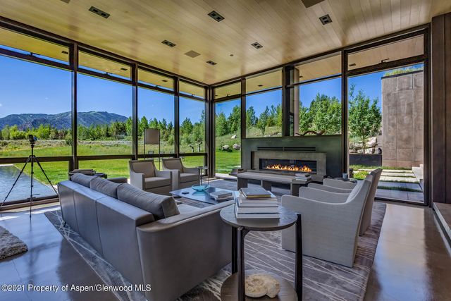 a living room with fireplace furniture and a large window