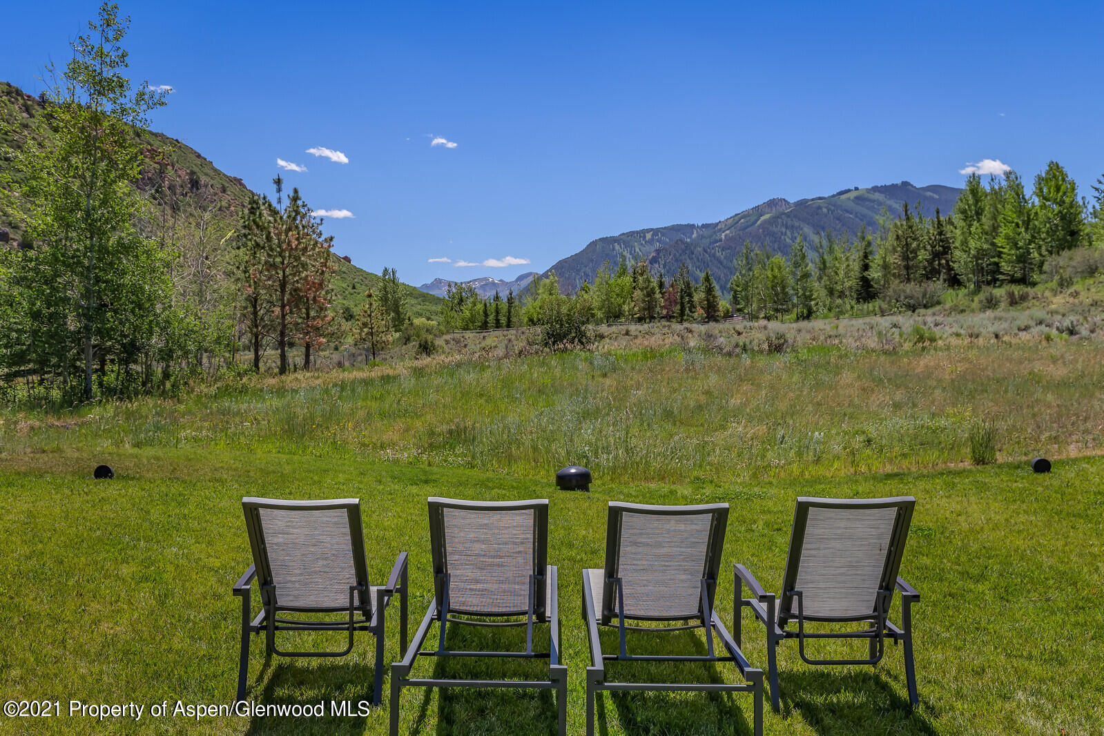276 Coach Road Aspen, CO 81611 - Photo 64 of 68 a view of a lake with table and chairs