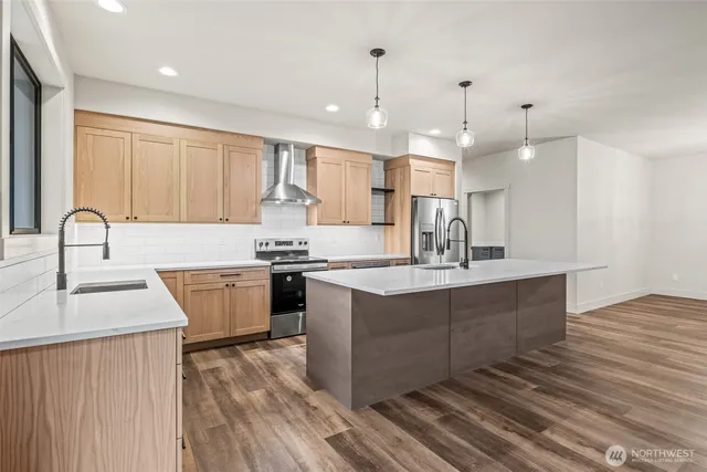 a kitchen with kitchen island granite countertop a sink cabinets and wooden floor
