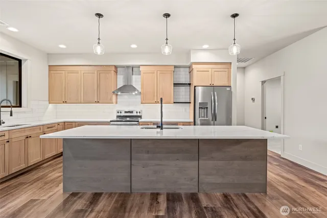 a large kitchen with kitchen island a sink stainless steel appliances and cabinets