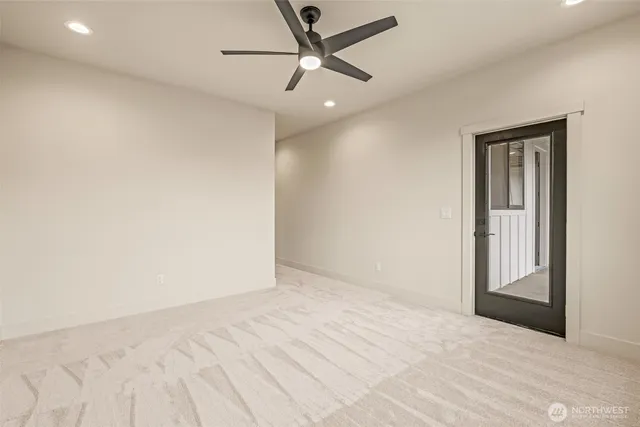 an empty room with a window and a ceiling fan