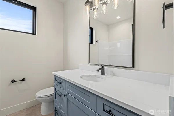 a bathroom with a sink a toilet and a mirror