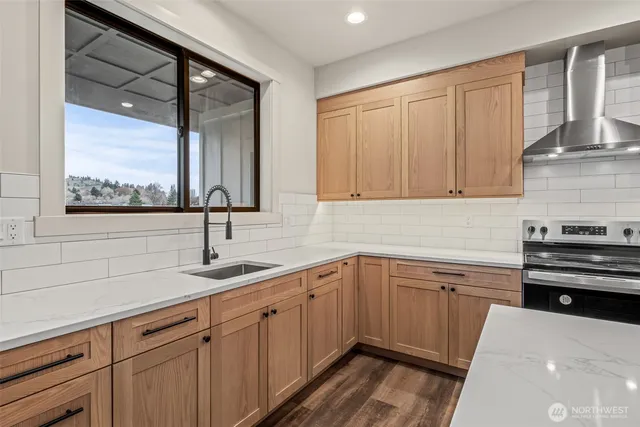 a kitchen with a sink dishwasher and cabinets with wooden floor