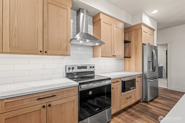 a kitchen with stainless steel appliances a stove a refrigerator and cabinets