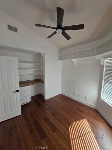 a view of empty room with wooden floor and window