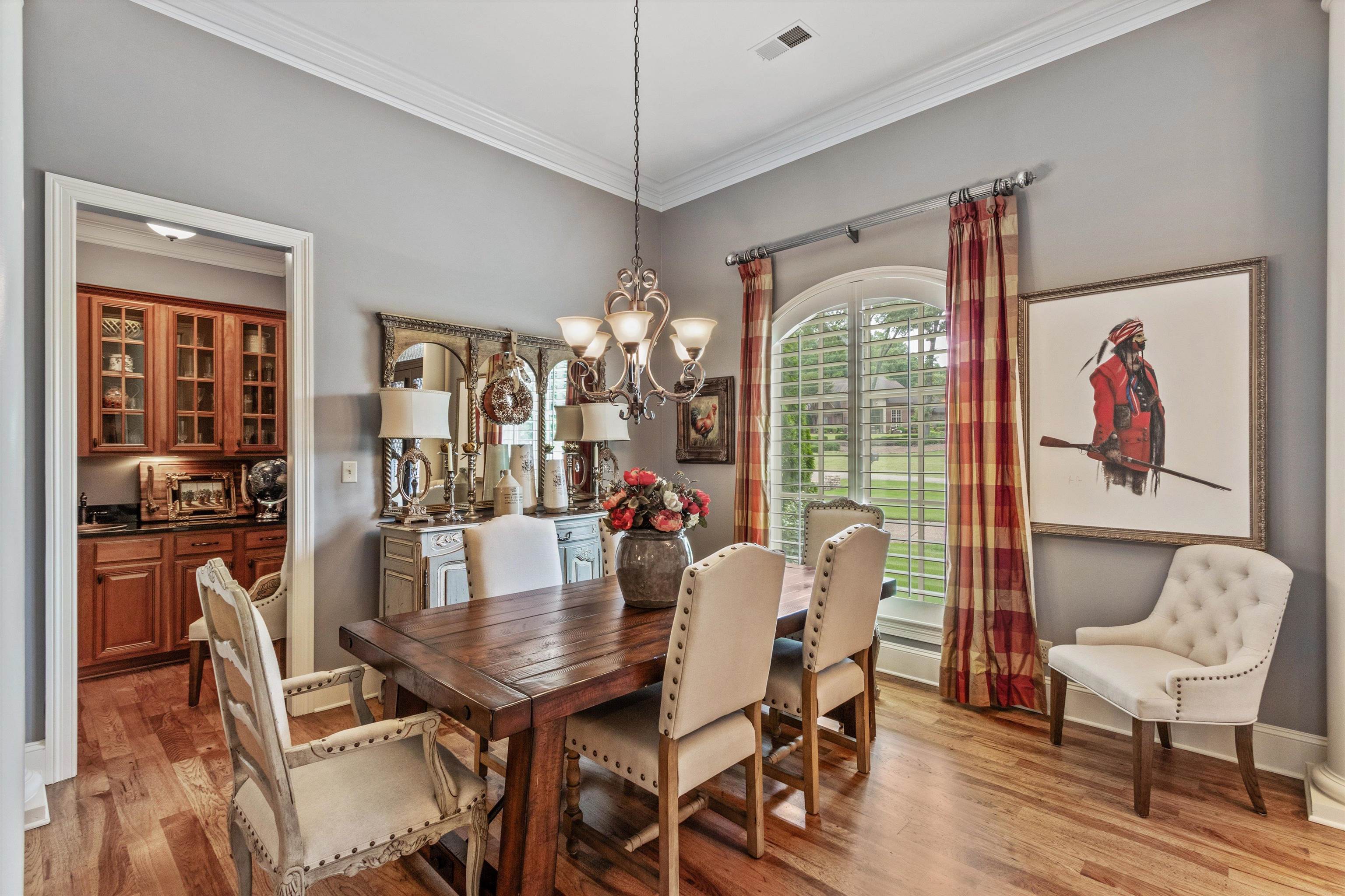 150 Ridgecrest Drive Arlington, TN 38002 - Photo 8 of 40 Dining area featuring wood-finish flooring, a chandelier, and an arched window with plantation shutters