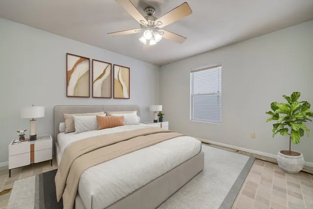 a bedroom with a bed and a potted plant